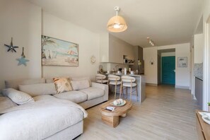 Una sala de estar con sofá, mesa de centro y un cuadro en la pared.
