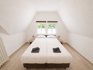 Habitació doble amb dos finestres, un radiador i una taula de nit amb làmpada.