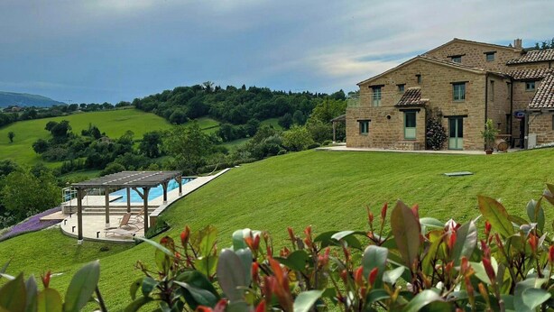 Ein Steinhaus mit Pool und Garten.