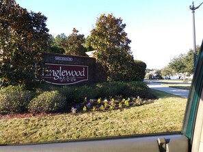Schild für ein Anwesen namens 'inglewood' mit einer Backsteinmauer und Zierpflanzen.