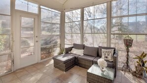 A sunroom with a sectional sofa, a glass coffee table, and a decorative lantern. - Relax & unwind in a spacious 3-bedroom townhouse with 4 beds in Barefoot Resorts (North Myrtle Beach)