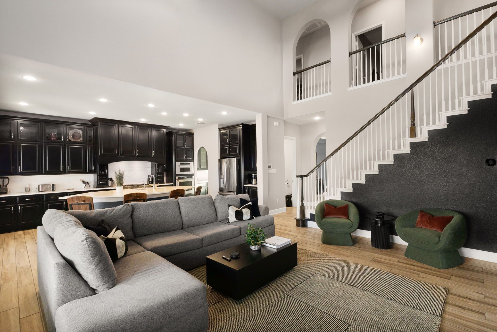 Un salon moderne avec un canapé d’angle, une table basse et un escalier.