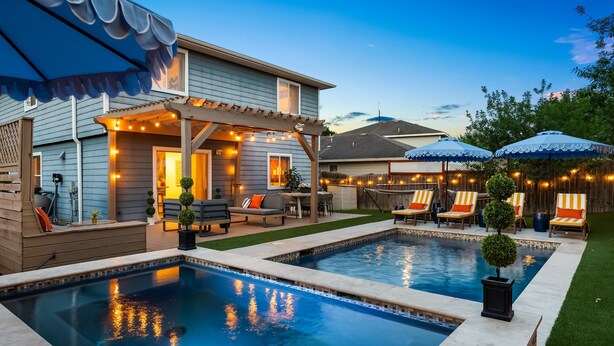 Un patio trasero con dos piscinas, un porche cubierto y mobiliario exterior.