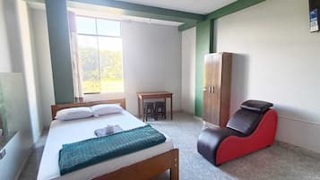 Un dormitorio con cama, escritorio, silla y armario.