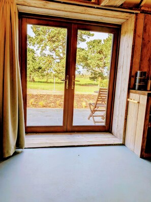 A room with a large sliding glass door leading to an outdoor area with a wooden ladder and a metal fence. - 6 Henham Barns, Henham Park, Nr Southwold, Suffolk (Suffolk)