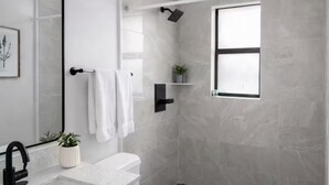 A modern bathroom with a white sink, a toilet, a shower, and a window. - Miami Luxury 2BR, FIFA Ready, Brickell (Miami)