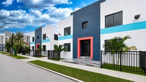 A modern residential building with a flat roof, large windows, and a red door. - Miami Luxury 2BR, FIFA Ready, Brickell (Miami)
