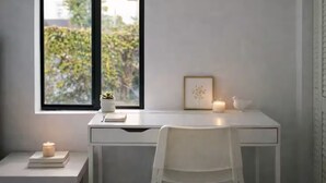 A minimalist room with a desk, chair, and a window overlooking greenery. - Miami Luxury 2BR, FIFA Ready, Brickell (Miami)