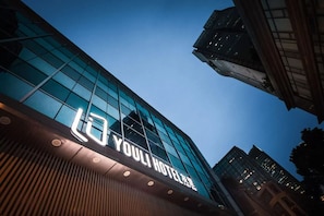 Un moderno edificio de hotel con un letrero llamativo que dice 'YOULI HOTEL'.