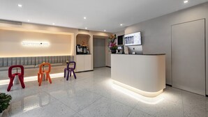 A modern reception area with a counter, seating, and a monitor. - Yooli Hotel shanghai (Shanghai)
