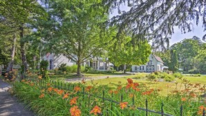 Een woonwijk met huizen, een pad en een tuin met oranje bloemen.