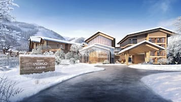 A hotel with a modern architectural design, featuring a large glass facade and wooden exterior.