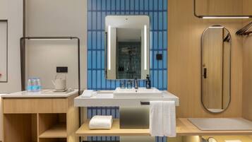 Een moderne badkamer met een wastafel, spiegel, handdoekhouder, douche en een houten wastafelmeubel.