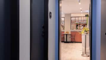 A hallway leading to a dining area with a bar, a staff-only sign, and a view into the room.