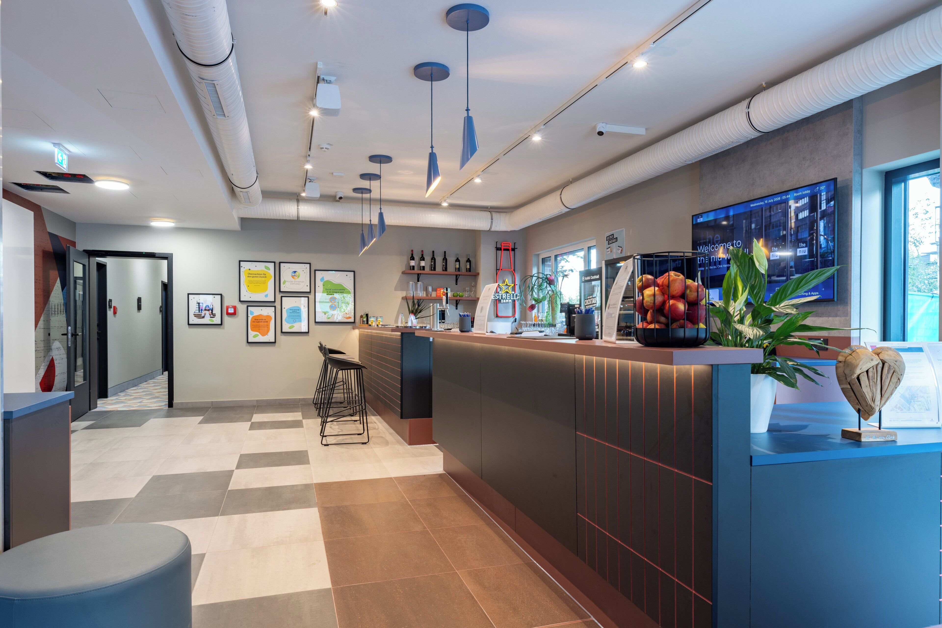 Un'area reception moderna con banco accettazione, posti a sedere e display digitale.