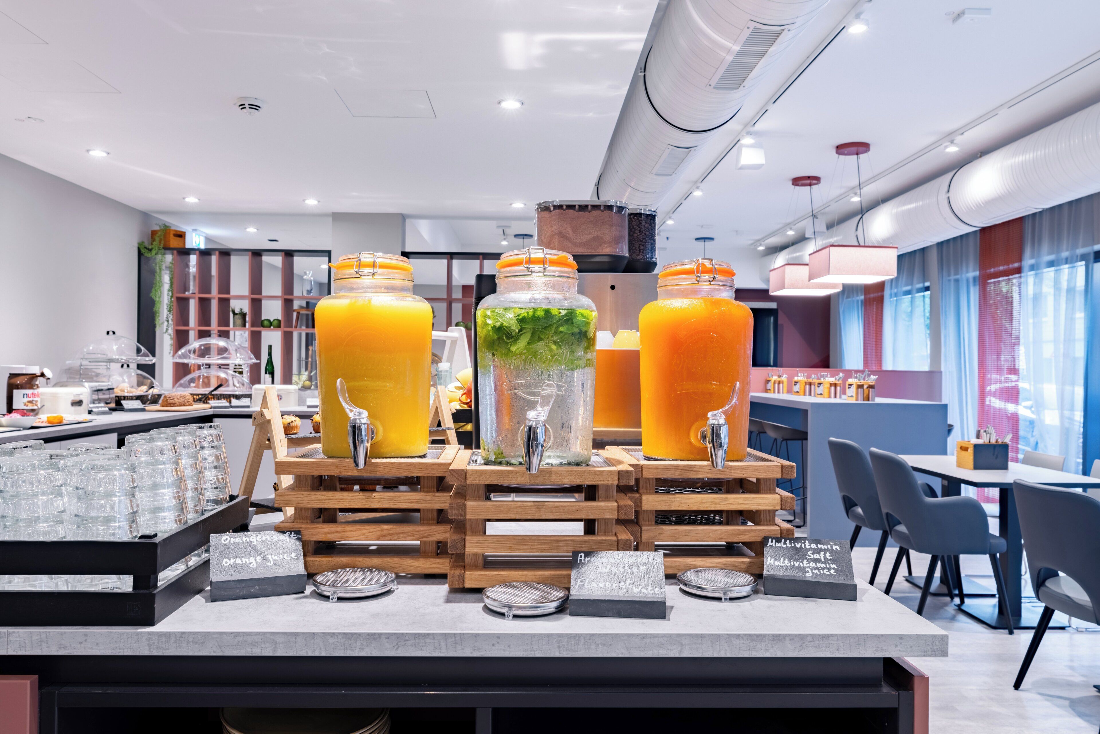 A juice bar with multiple dispensers, a coffee machine, and a seating area with tables and chairs.