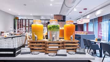 A juice bar with multiple dispensers, a coffee machine, and a seating area with tables and chairs.