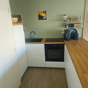 A compact kitchen with a built-in dishwasher, a coffee maker, and a small oven. - Propriano. Bright T2 apartment with outdoor area for 2 to 4 people. (Propriano)