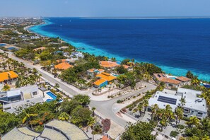 A coastal residential area with houses, a road, and a clear view of the ocean. - Casa Doce – Charming Ocean View Villa with Private Pool (Kralendijk)