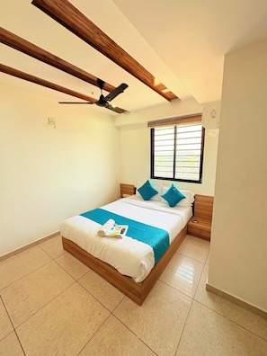 Un dormitorio con cama, ventilador de techo, ventana con persianas y aire acondicionado de pared.