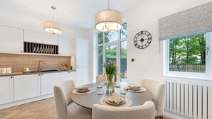 A modern kitchen with white cabinets, a wooden countertop, and pendant lighting. - NEW! Threadfold Townhouse - Peaceful Riverside Stay - Sleeps 6 (Bolton)