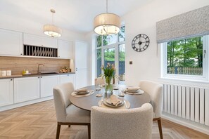 A modern kitchen with white cabinets, a wooden countertop, and pendant lighting. - NEW! Threadfold Townhouse - Peaceful Riverside Stay - Sleeps 6 (Bolton)