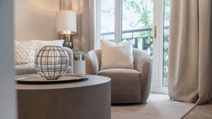 A cozy living room with a round coffee table, a lamp, and a sofa with cushions. - NEW! Threadfold Townhouse - Peaceful Riverside Stay - Sleeps 6 (Bolton)