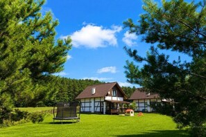 A two-story house with a large front lawn, a trampoline, and a small playhouse. - Holiday home on Lake Żarnowieckie (Lubkowo)