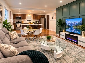 A modern living room with a sofa, coffee table, and a television. -     Stylish 3BR Retreat Minutes from NYC & World Cup Events (City of Orange)