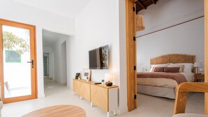 Ein Schlafzimmer mit einem Bett, Nachttischen, einem Fernseher und einem Holzstuhl.