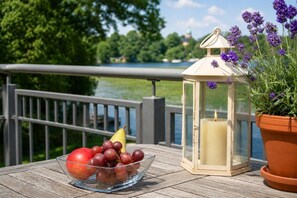 A table with a fruit bowl, a lantern, and a potted plant.