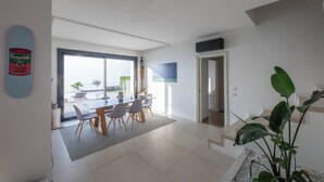 Un espace de vie moderne comprenant un coin repas, un escalier et une grande fenêtre.