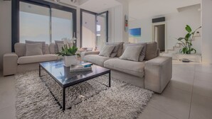 Un salon moderne avec deux canapés, une table basse et une grande fenêtre.