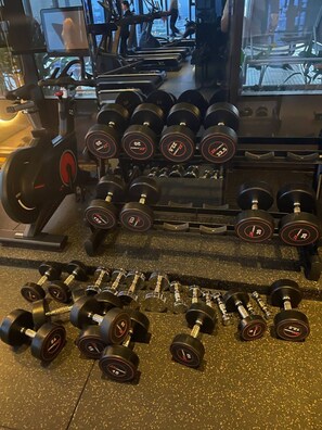 A gym with various exercise equipment, including dumbbells and treadmills. - City View Room At Vue Aston by VS (Phnom Penh-ភ្នំពេញ)