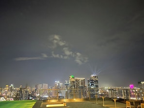 A nighttime cityscape with illuminated buildings and a clear sky.