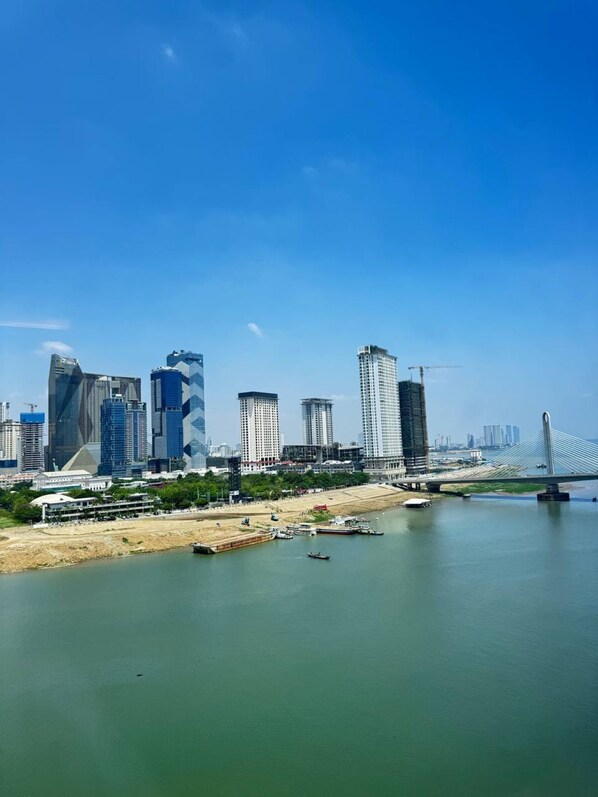 A cityscape with modern high-rise buildings, a river, and a bridge.