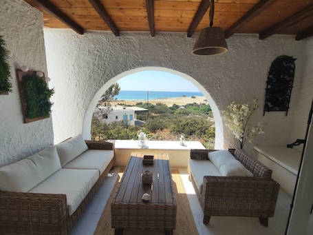Ein überdachter Außenbereich mit Blick auf den Strand und die Gebäude.. Irini's Home Sea View Naxos Dream by ΜΡS