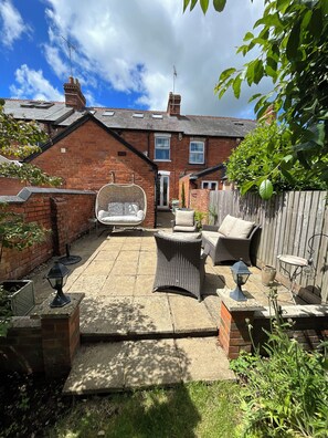 A patio with wicker furniture, a barbecue grill, and a brick wall. - A delightful two-bedroom home on Harpsden Rd offering an ideal escape. Sleeps 4. (Henley-on-Thames)