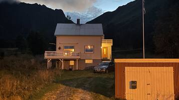 Ein zweistöckiges Haus mit Balkon, Garage und kleiner Werkstatt.