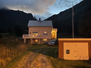 Ein zweistöckiges Haus mit Balkon, Garage und kleiner Werkstatt.
