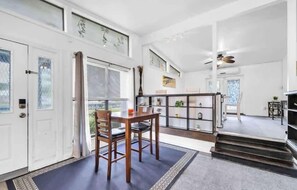 A spacious living area with a dining table, chairs, a staircase, and a bookshelf. - Cedar Family Retreat👙Private pool🐶Pet Friendly (Fort Walton Beach)