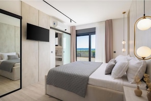 Ein modernes Hotelzimmer mit einem großen Bett, einem Flachbildfernseher, einem Balkon mit Blick und einer minimalistischen Einrichtung.