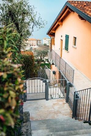 A staircase leading to a building with a tiled roof and a balcony. - Apartment 'Jessica' with Lake View, Wi-Fi and Air Conditioning (Torri del Benaco)
