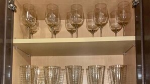 Un mobile contenitore con ripiani, con bicchieri da vino e tazze.