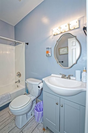 Une salle de bain avec des toilettes, un lavabo et une douche.