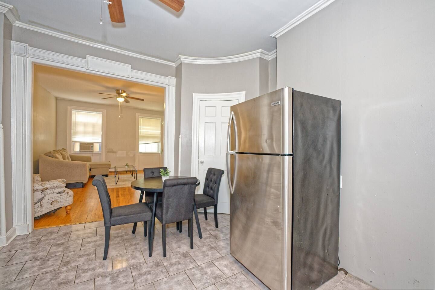 A compact living space with a dining area, a kitchenette, and a ceiling fan.