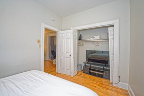 Ein Schlafzimmer mit einem Bett, einem Fernseher und einem begehbaren Kleiderschrank.