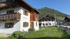 A traditional chalet with a balcony, a sign reading 'Sübertusheim,' and a mountain backdrop. - Alpenvilla Liboria Wallgau: 220-square-meter vacation home with hobby room (Wallgau)
