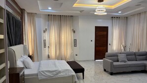 Una habitación de hotel moderna con una cama, sofá y una puerta de madera.