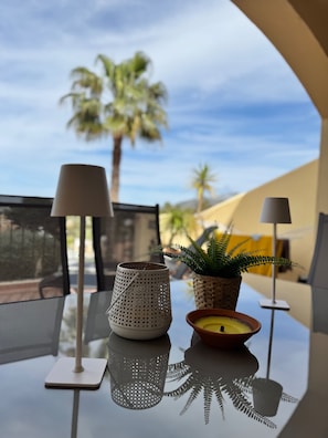 Ein Tisch mit einer Lampe, einer Kerze und einem Blumentopf.